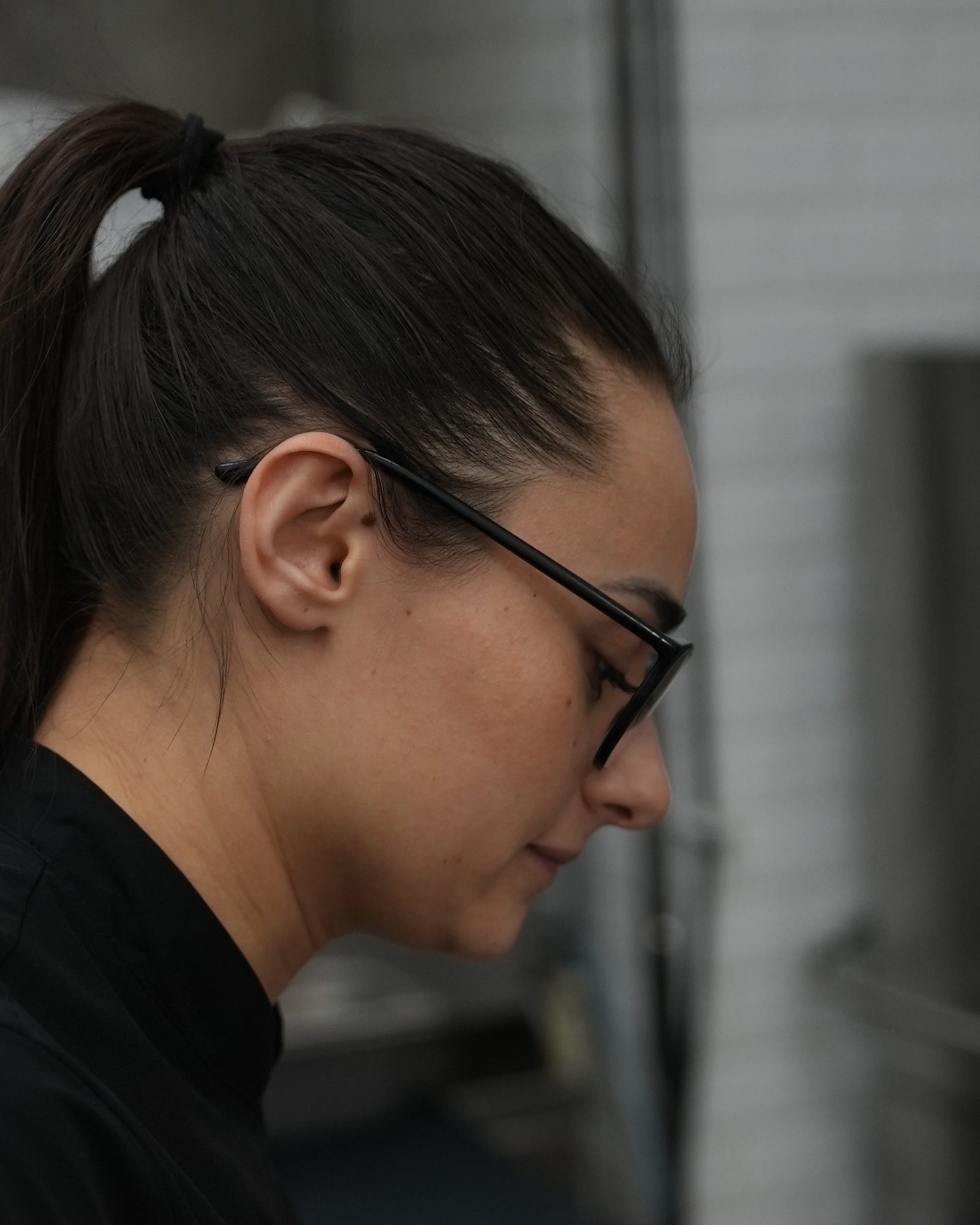 Giorgia di profilo, con gli occhiali, mentre lavora in cucina.